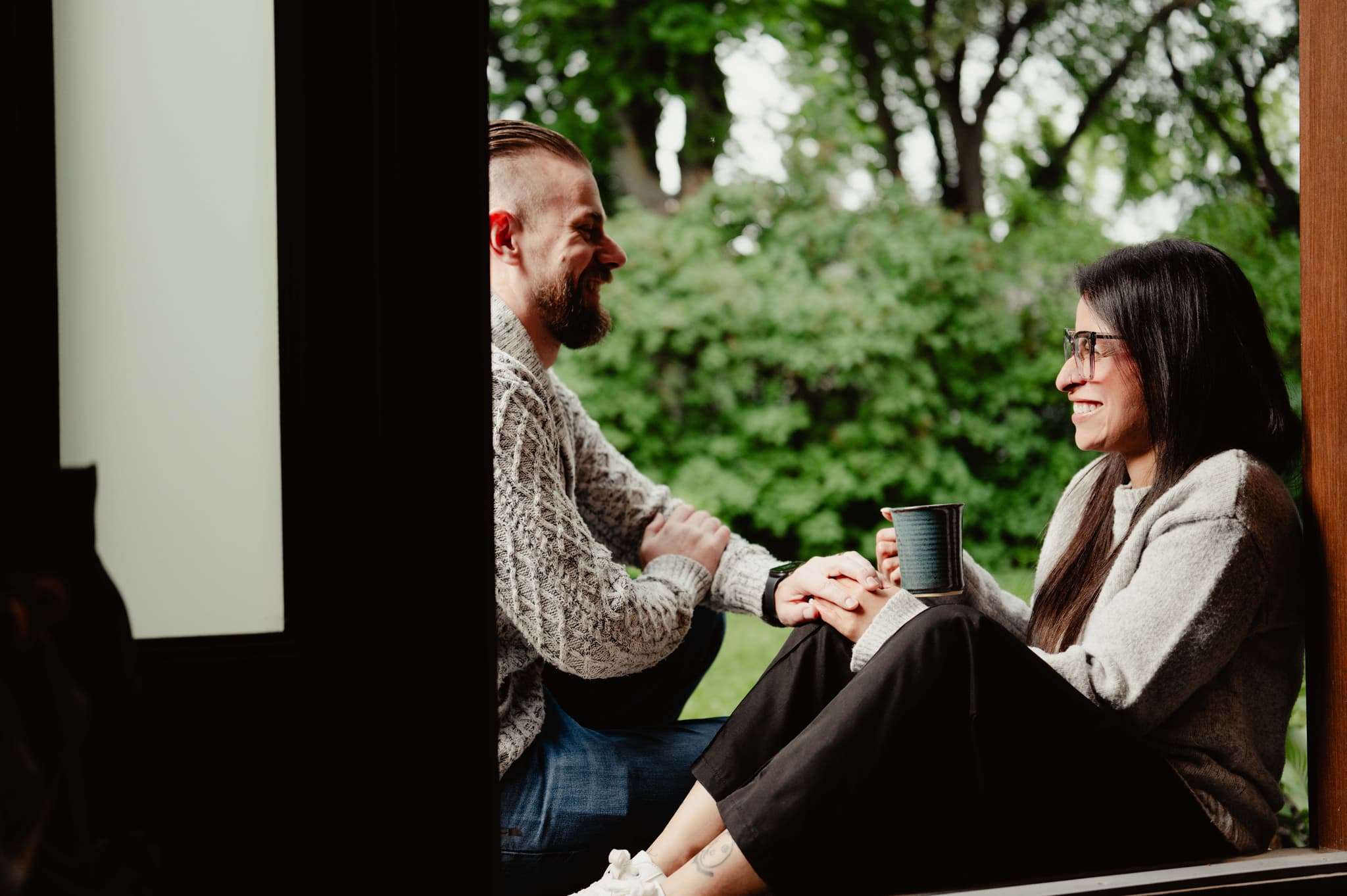 A couple sharing coffee and quiet conversation on a porch