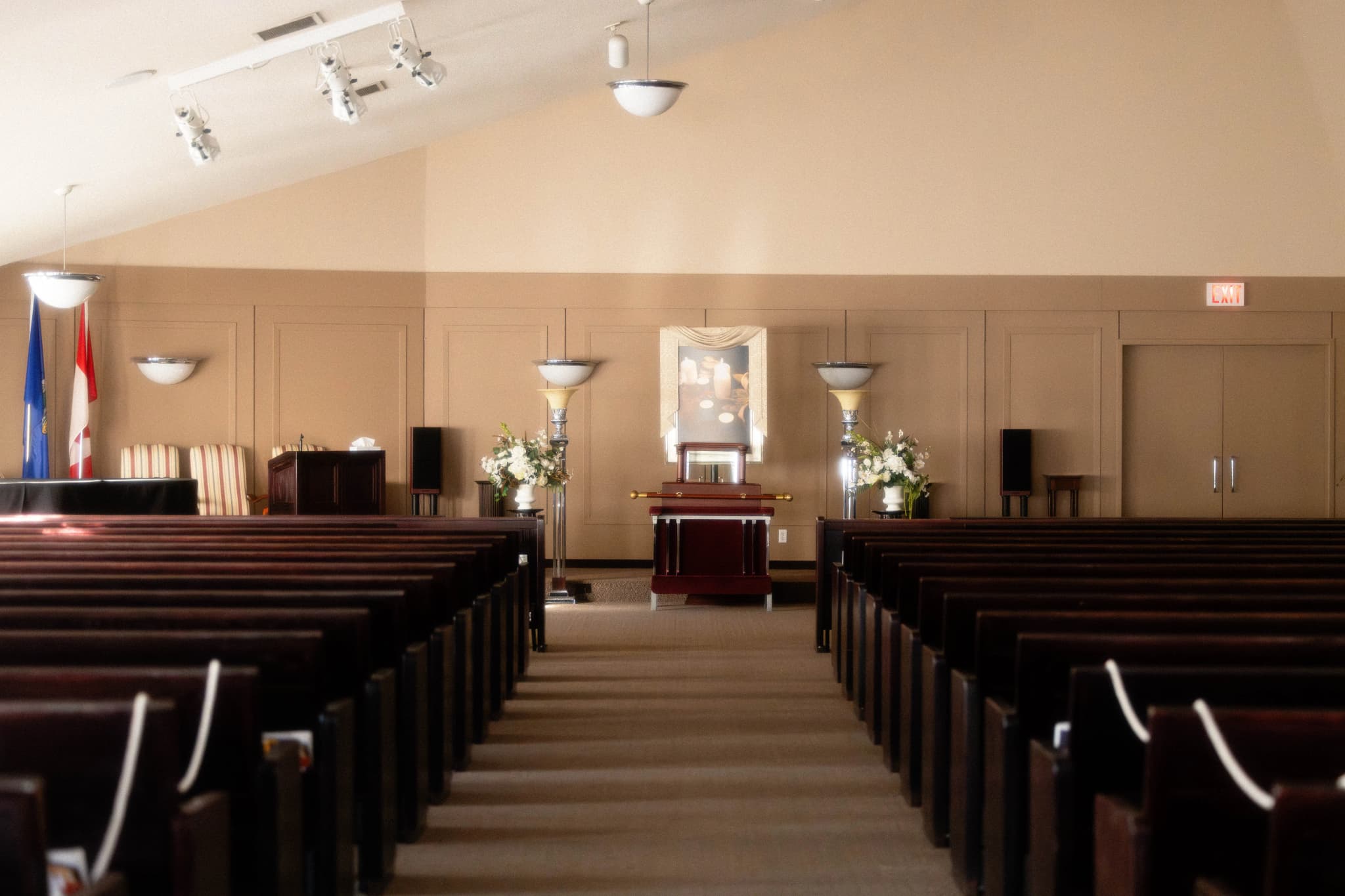 Spacious, serene funeral chapel at Martin Brothers Funeral Services in Lethbridge featuring elegant lighting and comfortable seating for large gatherings