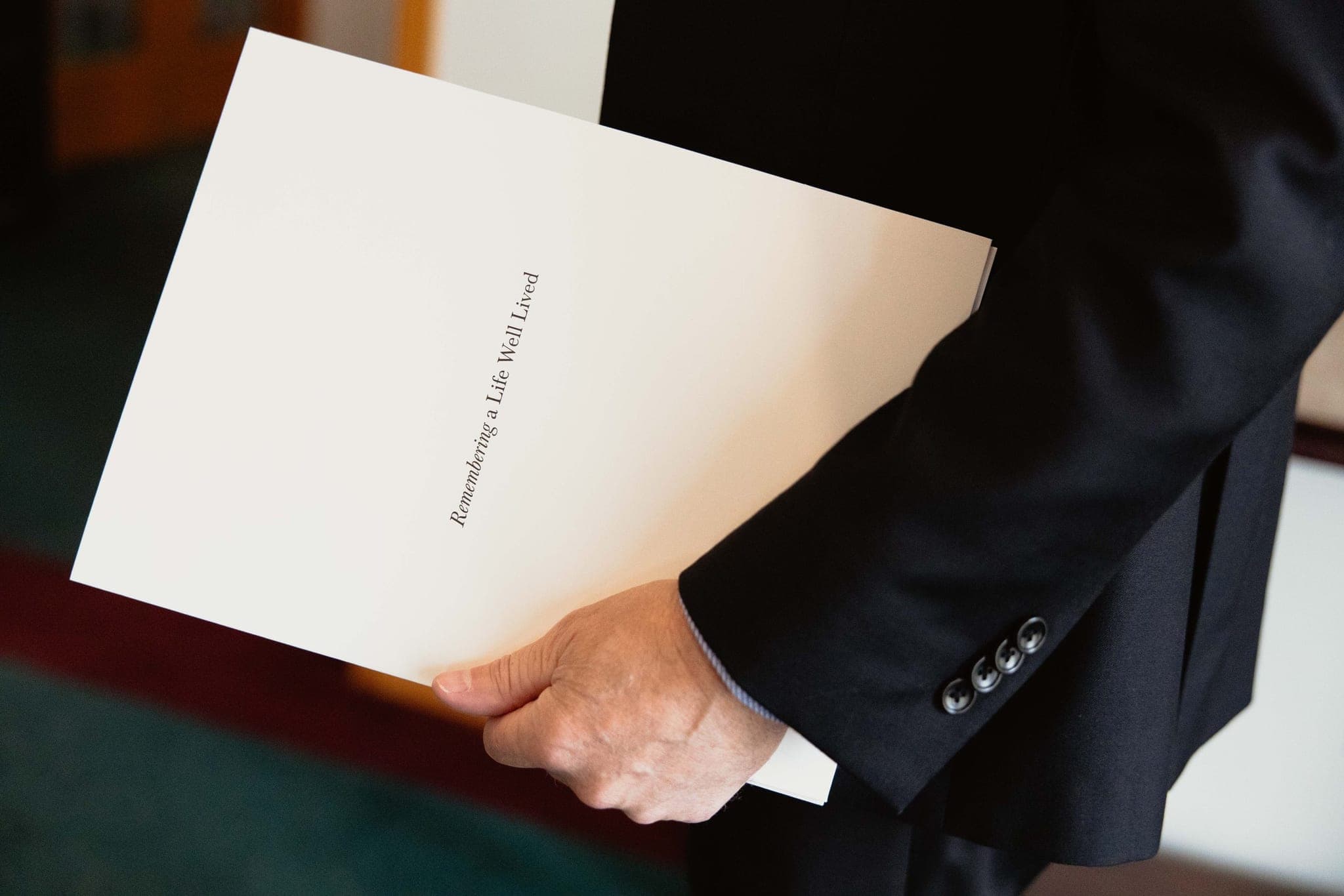 A Martin Brothers director holding the "Remembering a Life Well Lived" planning folder
