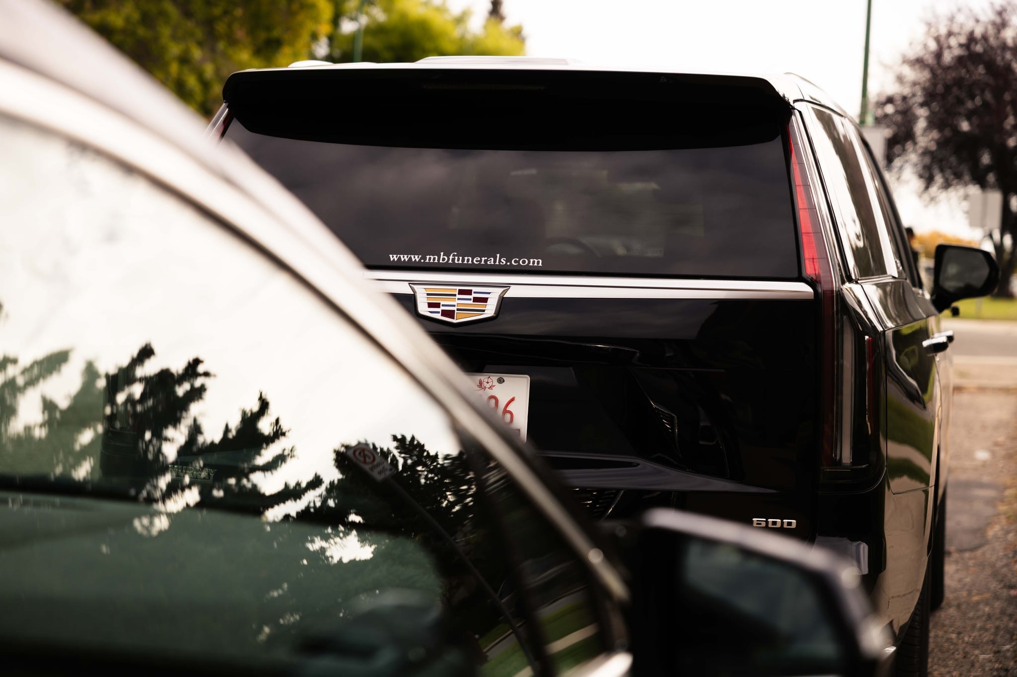 The rear of a black Cadillac Escalade bearing the Martin Brothers crest and mbfunerals.com